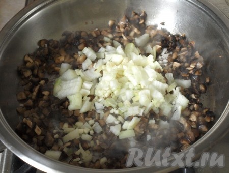 В сковороде разогреть подсолнечное масло, добавить грибы и обжарить их до золотистого цвета. Затем добавить к ним нарезанную луковицу и чеснок.