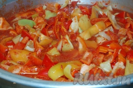 Отправим натертую морковь в томатное пюре и варим в кастрюле 20 минут, после чего отправим туда же и очищенный от семян, нарезанный перец.